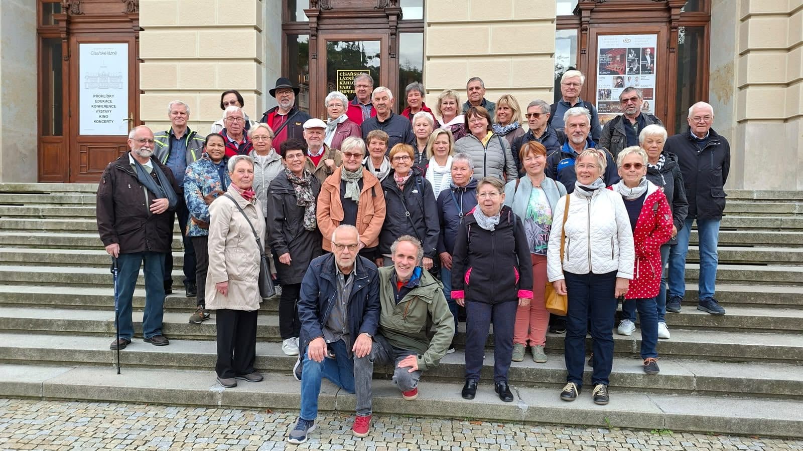 Reisegruppe auf den Stufen vor einem historischen Gebäude