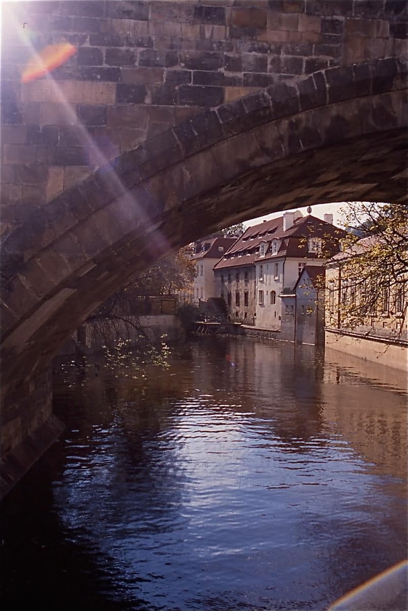 Blick durch einen Bogen der Karlsbrücke auf die Moldau